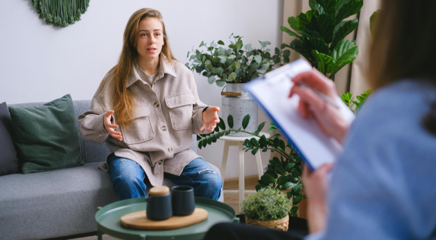 Séance de coaching : coach prenant des notes face à une cliente en train de s'exprimer